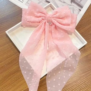 Detail of pink chiffon oversized bow hair clip featuring textured 3D raised dots