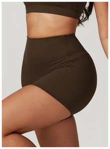 Detail of high-waisted dark brown sports shorts with seamless contouring and butt-lifting effect