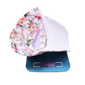 Detailed view of floral baseball cap on scale showing lightweight 69g design