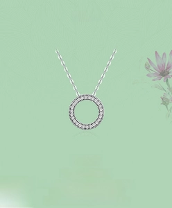 Détail macro du pendentif rond en argent avec cristaux pavés sur une chaîne classique