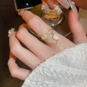Nahaufnahme eines goldenen Quastenrings mit Zirkonia-Akzenten an der Hand des Models