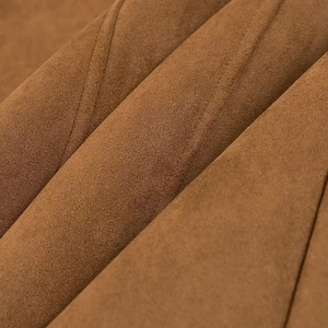 Vue macro du tissu en daim marron avec texture douce et plis naturels sur la veste