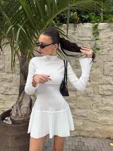 Elegante abito corto in maglia bianca a maniche lunghe con collo alto e volant