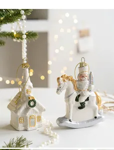 Detail of glittery white and gold house and nutcracker ornaments on a Christmas tree