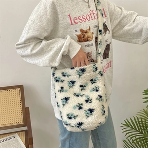 Close-up of fluffy white plush shoulder bag with blue floral print and soft texture
