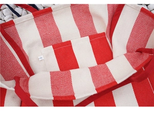 Detail view of the red and white striped canvas tote bag showing the inner slip pocket