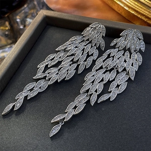 Detail of silver leaf tassel earrings with sparkling cubic zirconia on dark display box