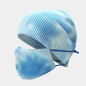 Detail view of tie-dye knit beanie and matching face mask set with blue sky pattern