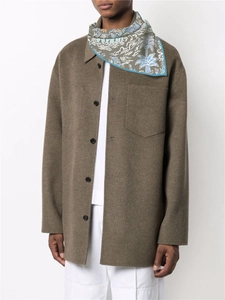 Detail of blue tropical pattern scarf paired with a brown wool coat on model