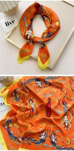 Detailed view of orange Dunhuang silk scarf with Flying Apsaras prints and yellow edges