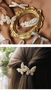 Detailed close-up of butterfly hair clip with cream pearls and sparkling rhinestones