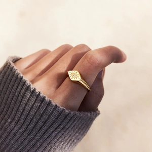Detailed close-up of a gold-plated evil eye ring with a central sparkling gemstone