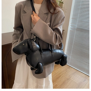 Creative black dachshund shaped bag worn with a gray suit for a stylish commuter look