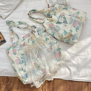 Detailed close-up of floral linen tote bag with delicate white lace mesh and embroidery