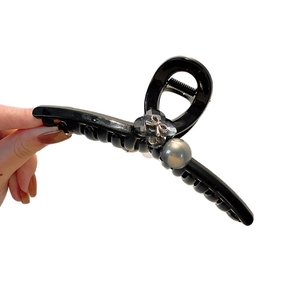 Elegant black glossy bow hair claw clip with pearl flower accent for women's hairstyles