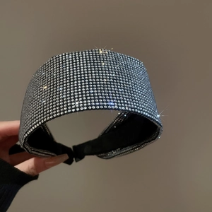 Close-up of high-density white rhinestones on wide black velvet padded headband