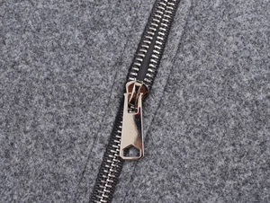Close-up of silver metal zipper detail on thick grey fleece bomber jacket texture