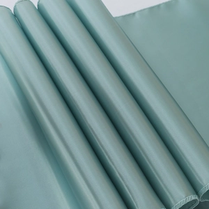 Detailed close-up of light blue satin fabric showing smooth texture and stitched edges
