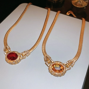 Macro detail of vintage oval pendant necklaces with diamond halo and gold snake chain
