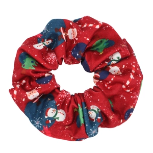 Detail shot of a red Christmas scrunchie featuring Santa, snowman, and candy cane prints