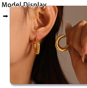 Detailed close-up of a model wearing a gold minimalist C-shape chunky hoop earring
