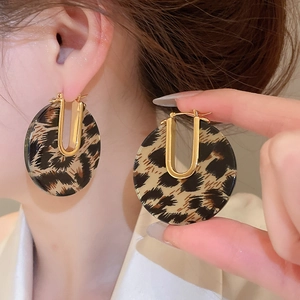 Détail des boucles d'oreilles en U plaqué or 18k avec anneaux en résine à motif léopard
