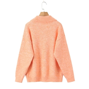 Détail de la vue arrière de ce pull en maille orange chaud présentant une texture douce