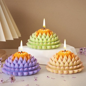 Three lotus succulent scented candles in purple green and pink with a lit wick