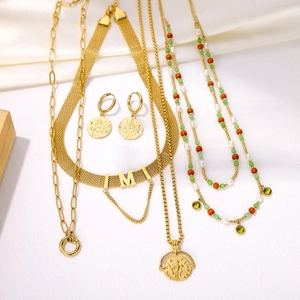 Detailed set of gold layered necklaces and coin earrings with green beads and pearls