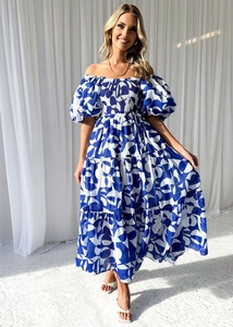 Detail of elegant off-shoulder floral maxi dress with puff sleeves and layered ruffle hem