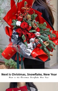 Detailed view of Christmas bouquet with red roses, pine branches and festive wrapping