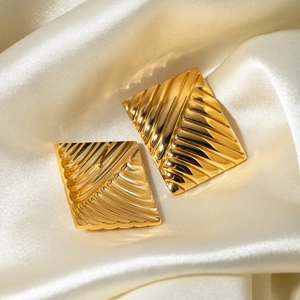 Detail showing rectangular gold stainless steel studs with a radial textured finish