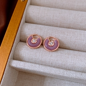 Detail view of rose gold stud earrings with purple stones and clear crystal accents