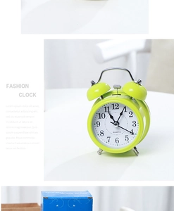 Detail of 3-inch fluorescent green twin bell alarm clock with metal hammer and handle