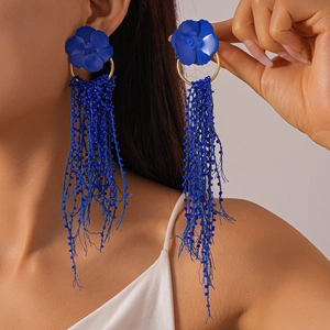 Detailed close-up of cobalt blue matte flower earrings with long beaded fringe tassels