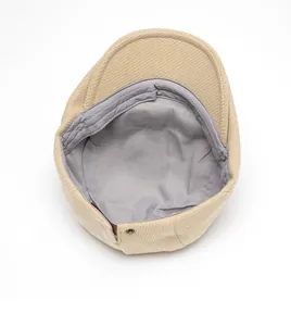 Detailed interior view of wool beret hat showing gray fabric lining and metal buckle