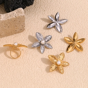 Macro detail of frangipani flower ring with pearl inlay in gold and silver plating