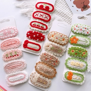 Detail view of colorful hand-knitted flower and fruit hair clips for girls