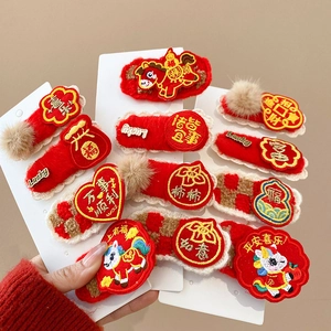 Detail of red plush Year of the Horse hair clips with gold festive Chinese embroidery
