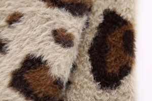 Nahaufnahme von weichem Strick mit Leopardenmuster zeigt Textur und feine Stoffdetails