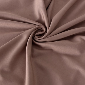 Macro shot of dark mauve ribbed stretch fabric showing fine texture and elegant drape