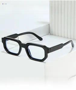Detail view of black square glasses frame with blue light blocking lenses on white podium