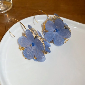 Eleganti orecchini a fiore in rete blu con filigrana dorata e dettagli in cristallo