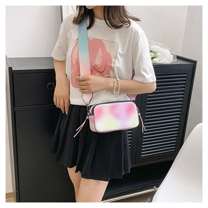 Detail of colorful gradient camera bag with a wide strap on a model outfit