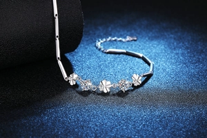 Macro shot of silver four-leaf clover bracelet featuring brilliant cut moissanite stones