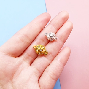 Macro detail of gold and silver magnetic jewelry clasps with rhinestones held in hand