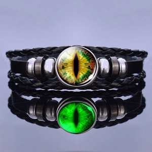 Detailed macro of woven leather bracelet with luminous green dragon eye glass cabochon