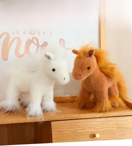 Close-up of white and brown plush pony dolls showing soft fluffy texture on wood surface