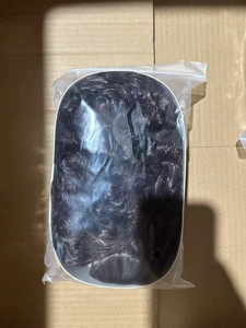 Detail view of long curly hair wig with bangs in transparent plastic packaging