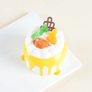 Detailed macro view of artificial mini cake with cream and realistic fruit toppings